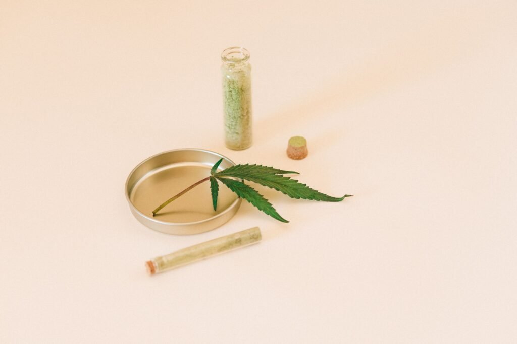 cannabis leaf medical cannabis pre rolled joint in tube, pink background